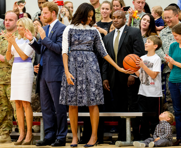 First lady Michelle Obama passes the game basketball on to a young member of the crowd, Wednesday, Oct. 28, 2015 in Fort Belvoir, Va. (Photo by Andrew Harnik/AP)