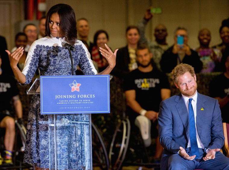 Britain's Prince Harry reacts as first lady Michelle Obama makes a comment about the USA's performance in the upcoming Invictus Games Orlando 2016 as they speak to wounded servicemen at Fort Belvoir military base, Oct. 28, 2015 (Photo by Andrew Harnik/AP)