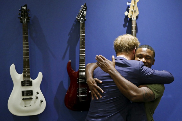 Britain's Prince Harry hugs U.S. Marine Sgt. Roderic Liggens in the music room during a tour of the USO Warrior and Family Center at Fort Belvoir, Va, Oct. 28, 2015. (Photo by Kevin Lamarque/Reuters)