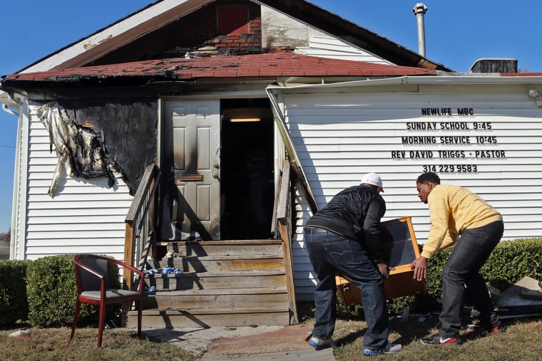In this Sunday, Oct. 18, 2015 photo, Deacon Clinton McMiller and Pastor David Triggs carry a cabinet after an outdoor service due to a fire at the New Life Missionary Baptist Church in St. Louis. (Photo by J.B. Forbes/St. Louis Post-Dispatch/AP)