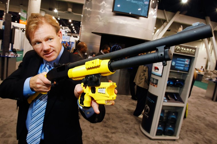 Taser International vice president of communications Steve Tuttle displays a shotgun that fires Taser rounds at CES 2009 at the Las Vegas Convention Center Jan. 9, 2009 in Las Vegas, Nev. (Photo by Ethan Miller/Getty)