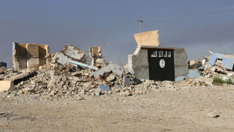 A destroyed building with a wall painted with the black flag commonly used by Islamic State militants, is seen in the town of al-Alam March 10, 2015. (Photo by Thaier Al-Sudani/Reuters)