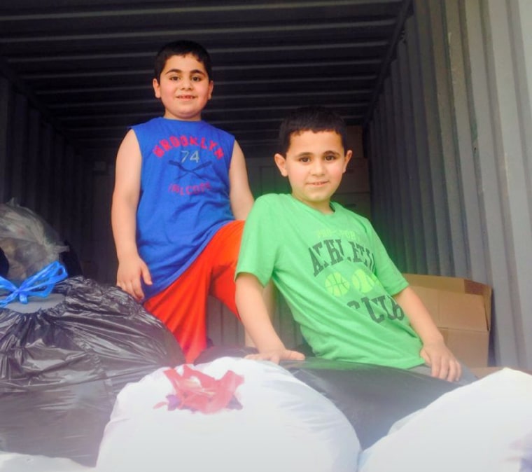 Amjad's sons, Ayoub, 7, and Omar, 6, pack donated goods in Toledo, Ohio, to send to other Syrian refugees in Jordan. (Photo by Amanda Sakuma)