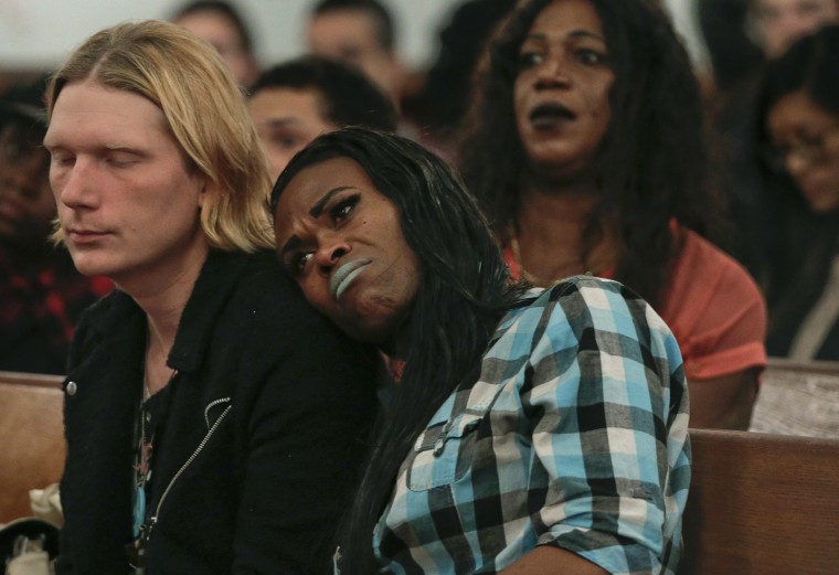A couple attending a Trans Day of Remembrance program listen during a speech about violence against transgender people, in New York, Nov. 18, 2015. (Photo by Julie Jacobson/AP)
