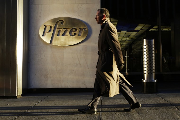 A man walks past Pfizer World Headquarters, Nov. 23, 2015 in New York. (Photo by Mark Lennihan/AP)