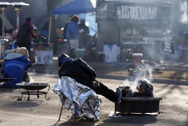 A protester gets some rest at the Black Lives Matter encampment, Tuesday, Nov. 24, 2015, outside the Minneapolis Police Department's Fourth Precinct in Minneapolis. (Photo by Jim Mone/AP)