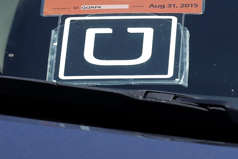 An Uber sign is displayed on a driver's car, July 15, 2015. (Photo by Jeff Chiu/AP)