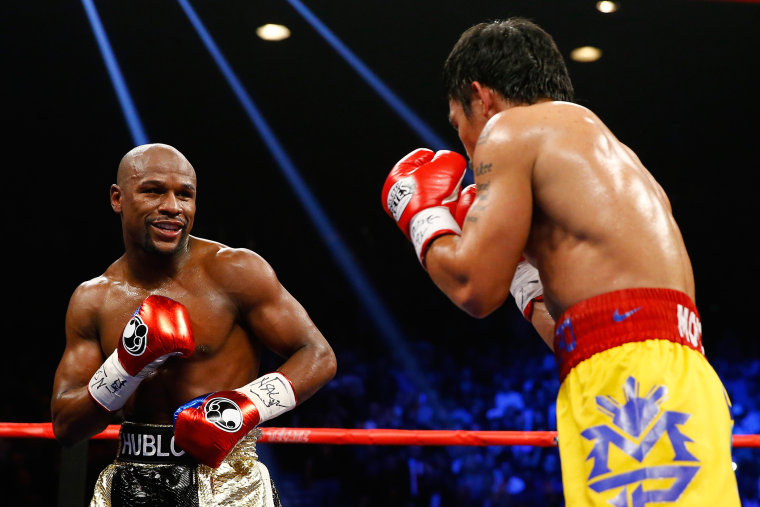 Floyd Mayweather Jr. smiles at Manny Pacquiao during their welterweight unification championship bout on May 2, 2015 at MGM Grand Garden Arena in Las Vegas, Nev. (Photo by Al Bello/Getty)