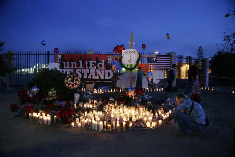 People pay respects at a makeshift memorial honoring the victims of Wednesday's shooting rampage, Dec. 5, 2015, in San Bernardino, Calif. (Photo by Jae C. Hong/AP)