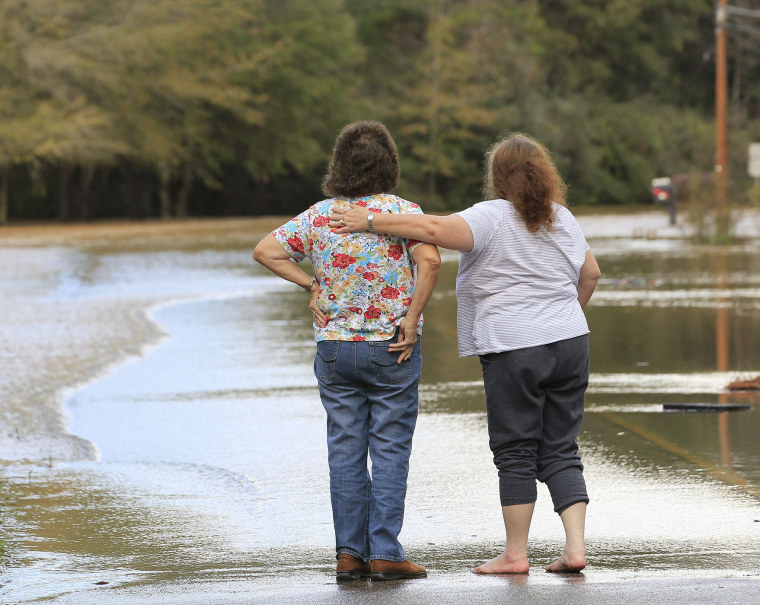 Neighbors console each other after floods waters entered their business in Elba, Ala., Dec. 26, 2015. (Photo by Marvin Gentry/Reuters)
