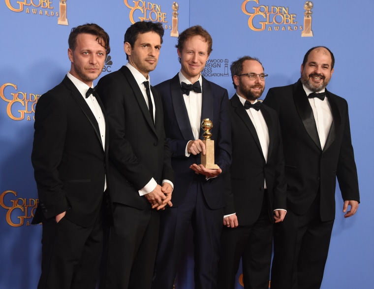 Director Laszlo Nemes, actor Geza Rohrig, and other members of the \"Son of Saul\" team pose with the award for Best Foreign Language film at the Golden Globe Awards, Jan. 10, 2016, at the Beverly Hilton Hotel, Calif. (Photo by Frederic J. Brown/AFP/Getty)