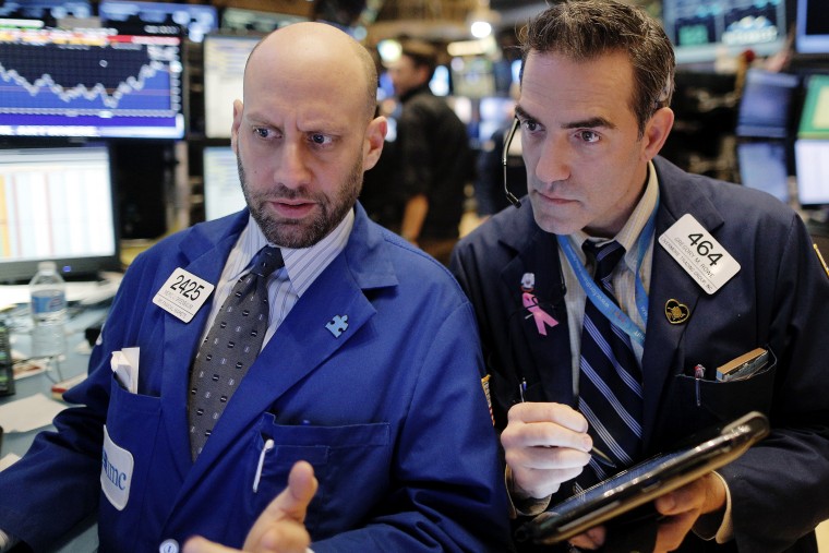 Specialist trader Meric Greenbaum gives a price quote to trader Greg Rowe on the floor of the New York Stock Exchange, Jan. 13, 2016. (Photo by Brendan McDermid/Reuters)