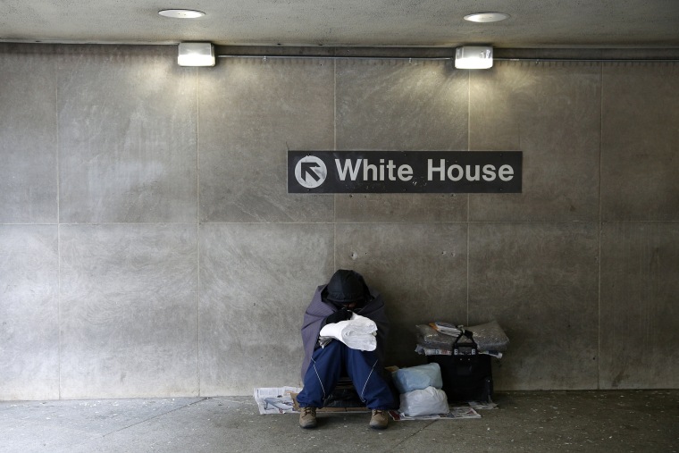On an unseasonably cold day, a homeless person tries to stay warm at the entrance of a subway station near the White House in Washington, Jan. 20, 2016. (Photo by Kevin Lamarque/Reuters)