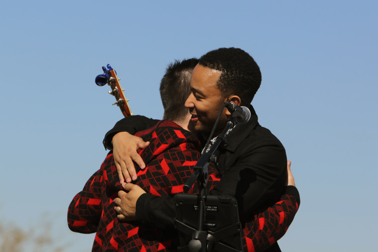 John Legend, front, and Colombian rock star Juanes hug each other after performing in front of a detention center in Eloy, Arizona, Jan. 20, 2016. (Photo by Ricardo Arduengo/AP)
