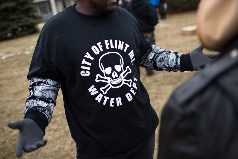 A shirt worn by a man during a rally displays a poisonous logo alongside the text 'City of Flint MI Water Dept.' on Jan. 24, 2016 at Flint City Hall in Flint, Mich. (Photo by Brett Carlsen/Getty)