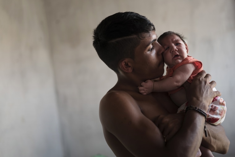 In this Dec. 23, 2015 photo, Dejailson Arruda holds his daughter Luiza at their house in Santa Cruz do Capibaribe, Pernambuco state, Brazil. (Photo by Felipe Dana/AP)