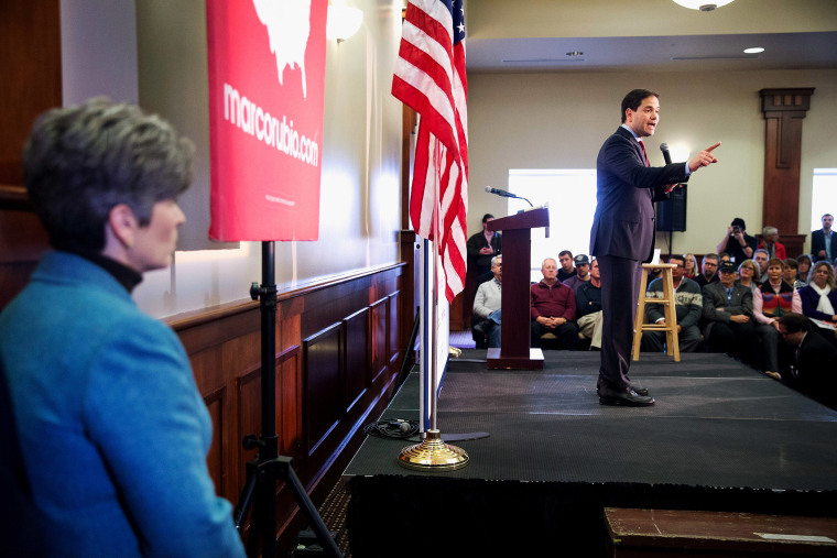 Sen. Joni Ernst (R-IA) listens as Republican presidential candidate Sen. Marco Rubio (R-FL) speaks at a rally on Jan. 25, 2016 in Des Moines, Iowa. (Photo by Scott Olson/Getty)