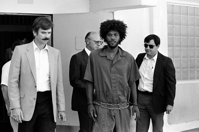 Kevin Cooper, center, is escorted to a car for transport to San Bernardino from Santa Barbara, Calif., after he was arrested by police at Santa Cruz Island, July 31, 1983. (File photo by AP)