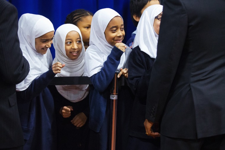 Young girls close their hands in anticipation of 'fist-bumping' President Barack Obama, right, after he spoke at the Islamic Society of Baltimore, Feb. 3, 2016, in Baltimore, Md. (Photo by Pablo Martinez Monsivais/AP)