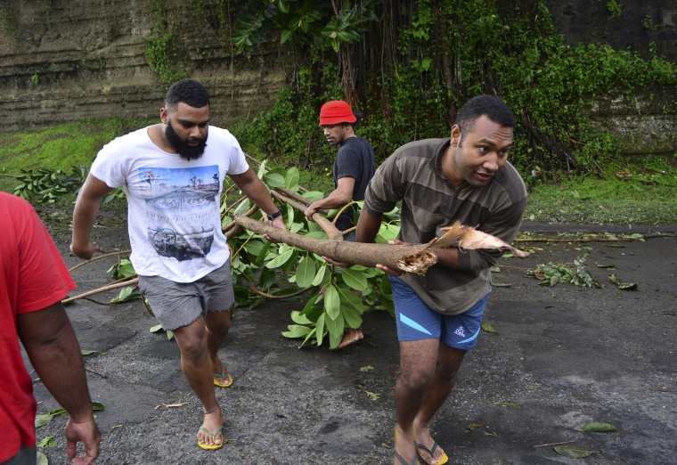 Fijian men clear a road of a fallen tree in Fiji's capital Suva after Cyclone Winston swept across Viti Levu Island, Feb. 21, 2016. (Photo by Taniela Qalilawa/Reuters)
