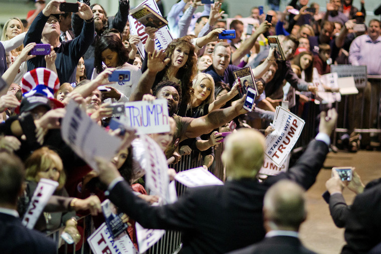 Audience members cheer as Republican presidential candidate Donald Trump signs autographs at a campaign event, Feb. 21, 2016, in Atlanta, Ga. (Photo by David Goldman/AP)