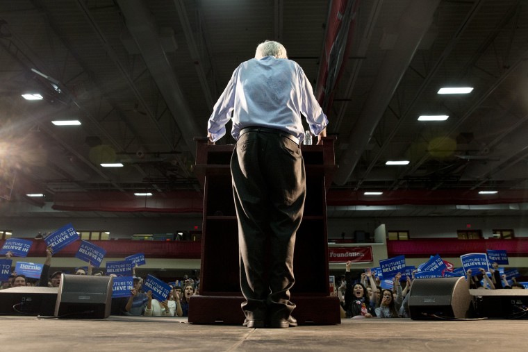 Having removed his suit jacket from the heat, Democratic presidential candidate Sen. Bernie Sanders, I-Vt., pauses as people cheer during a campaign rally at Milton High School in Milton, Mass., Feb. 29, 2016. (Photo by Jacquelyn Martin/AP)