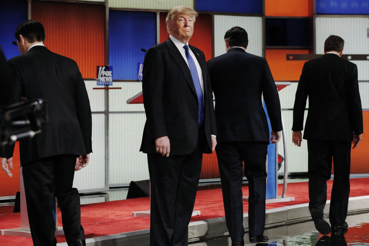 Republican presidential candidate Donald Trump remains standing at the front of the stage as his rivals head to their podiums at the start of a debate in Detroit, Mich., March 3, 2016. (Photo by Jim Young/Reuters)