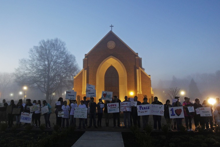 Protesters wait before dawn outside a church at Lenoir-Rhyne University before a rally for Republican presidential candidate Donald Trump in Hickory, N.C., March 14, 2016. (Photo by Chuck Burton/AP)