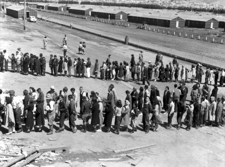 Newly arrived Japanese evacuees line up outside a mess hall at the Tanforan Assembly Center, in San Bruno, Ca., April 29, 1942. (Photo by Dorothea Lange/Interim Archives/Getty)