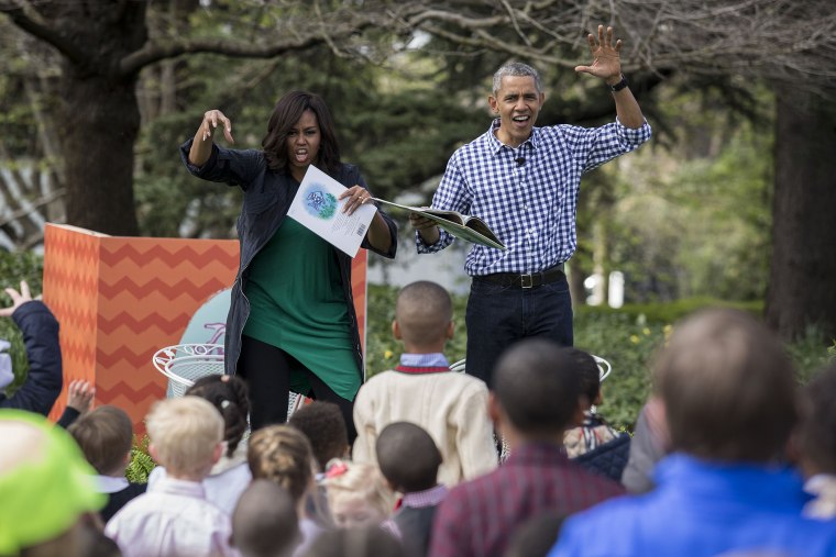 President Barack Obama and first lady Michelle Obama gesture as they read from the book \"Where the Wild Things Are\" during the annual White House Easter Egg Roll on the South Lawn of the White House March 28, 2016 in Washington, D.C.