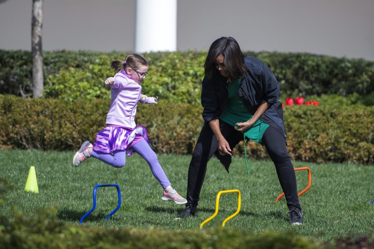 First Lady Michelle Obama encourages a young girl while she participates in an activity that is part of the White House Easter Egg Roll on the South Lawn of the White House in Washington, D.C., March 28, 2016. (Photo by Shawn Thew/EPA)