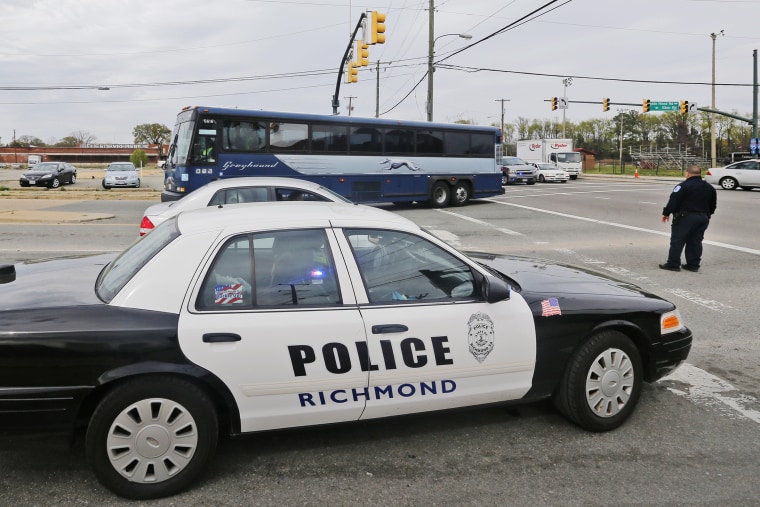 A Greyhound bus passes a police cruiser as it heads to the terminal, March 31, 2016, in Richmond, Va. (Photo by Steve Helber/AP)