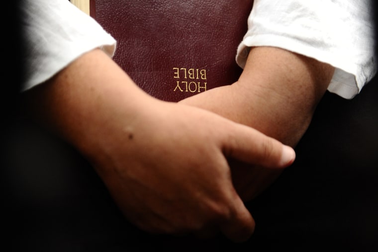A woman holds a Bible. (Photo by Robertus Pudyanto/Getty)
