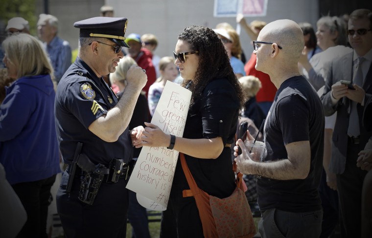 A police officer confronts a lady at the State Capitol in Raleigh, N.C., April 11, 2016, during a rally in support of a law that blocks rules allowing transgender people to use the bathroom aligned with their gender identity. (Photo by Gerry Broome/AP)