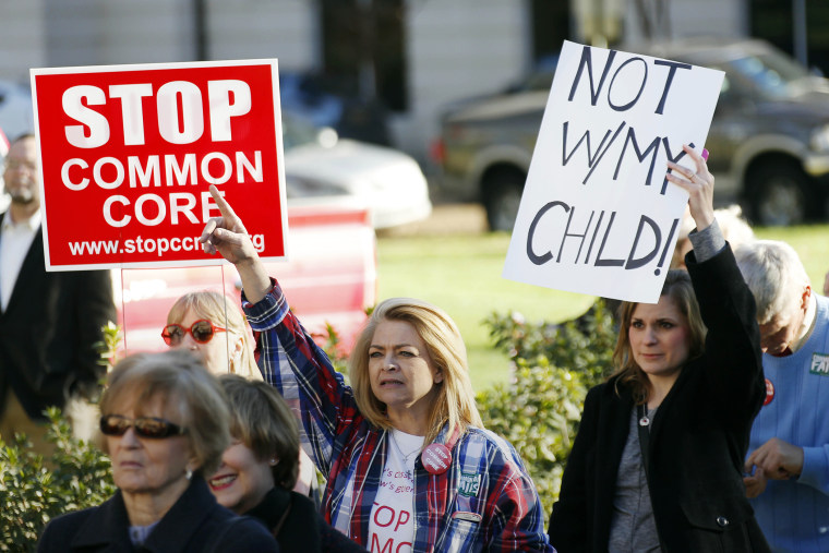 Common Core opponents wave signs and cheer at a rally opposing Mississippi's continued use of the Common Core academic standards on the steps of the Capitol in Jackson, Miss., Jan. 6, 2015. (Photo by Rogelio V. Solis/AP)