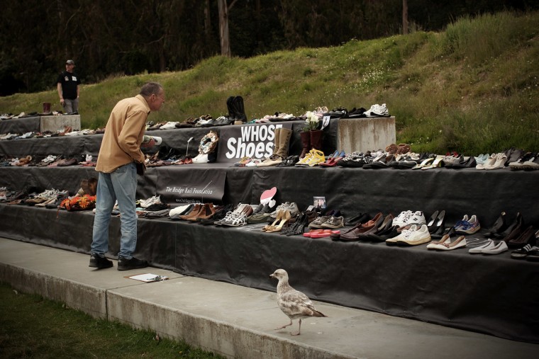 A man looks at a display of more than 1,000 pairs of shoes belonging to people who have jumped to their death from the Golden Gate Bridge in San Francisco, Calif., May 27, 2012. (Photo by Robert Galbraith/Reuters)