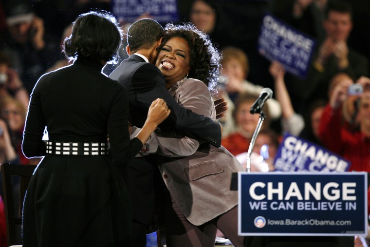 Democratic presidential hopeful, Sen. Barack Obama, D-Ill.. gets a hug from Oprah Winfrey as his wife Michelle, left, looks on during a rally, Dec. 8, 2007, in Des Moines, Iowa. (Photo by Charlie Neibergall/AP)