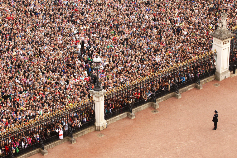A general view of the gates of Buckingham Palace in front of the Victoria Memorial filled with well-wishers celebrating the Royal Wedding of Prince William and Kate, the Duchess of Cambridge, Friday, April 29, 2011. (Photo by Oli Scarff/AP)