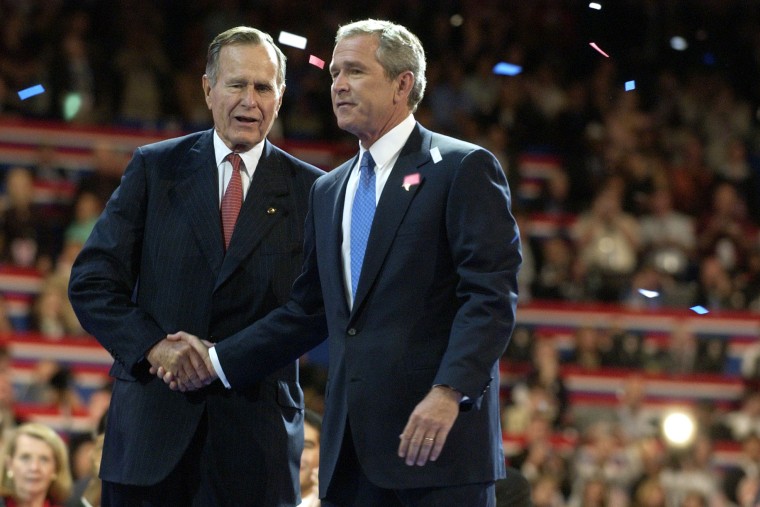 Former President George Herbert Walker Bush, left, congratulates his son, then current US President George W. Bush during the final session of the Republican National Convention in New York, Sept. 2, 2004. (Photo by Mike Mergen/Bloomberg/Getty)