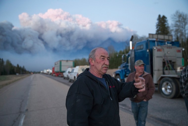 Drivers wait for clearance to take firefighting supplies into town on May 5, 2016 outside of Fort McMurray, Alberta. (Photo by Scott Olson/Getty)