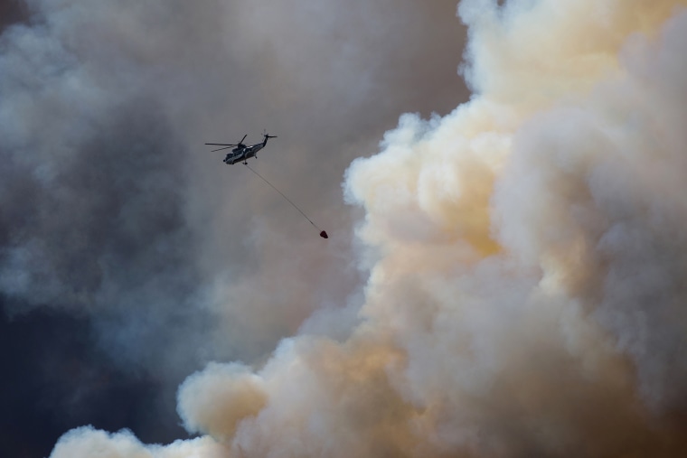 A helicopter flies into thick smoke while battling a major forest fire outside of Fort McMurray May 4, 2016. (Photo by Topher Seguin/Reuters)