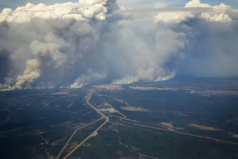 Wildfires burn in and around Fort McMurray, Alberta, May 4, 2016. (Photo by Jeff McIntosh/The Canadian Press/AP)