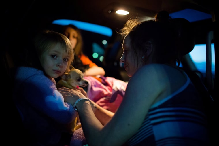 Fort McMurray resident Crystal Maltais buckles in her daughter, Mckennah Stapley, as they prepare to leave Conklin, Alberta, for Lac La Biche after evacuating their home in Fort McMurray on May 3, 2016. (Photo by Topher Seguin/Reuters)