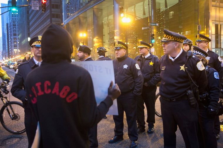 A demonstrator confronts police during a march through downtown on Dec. 12, 2015 in Chicago, Ill. (Photo by Scott Olson/Getty)