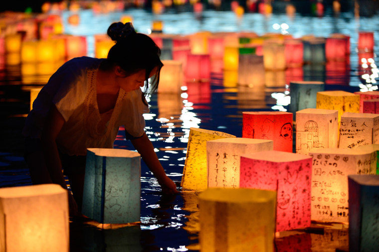A woman floats paper lanterns lit in remembrance for victims of the 1945 atomic bombing of Hiroshima on the Motoyasu River at the Peace Memorial Park in Hiroshima, western Japan, on Aug. 6, 2013. (Photo by Toru Yamanaka/AFP/Getty)