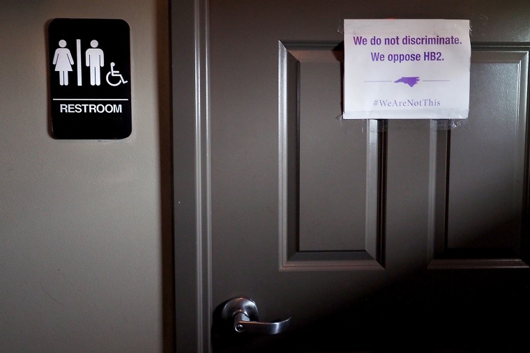 A unisex sign and the \"We Are Not This\" slogan are outside a bathroom at Bull McCabes Irish Pub on May 10, 2016 in Durham, N.C. (Photo by Sara D. Davis/Getty)