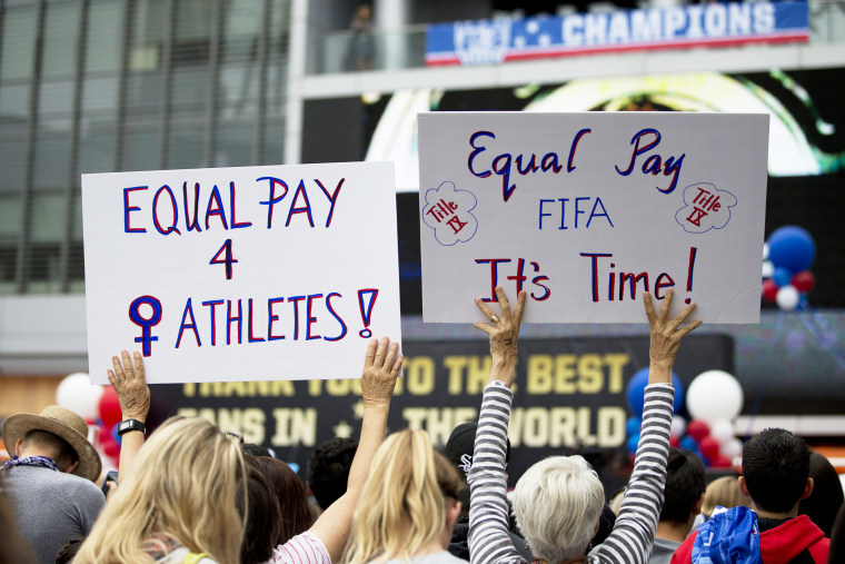 Two women hold up signs demanding equal pay for female athletes during a public rally held to celebrate the U.S. women's soccer team's World Cup championship on July 7, 2015, in Los Angeles, Calif. (Photo by Jae C. Hong/AP)