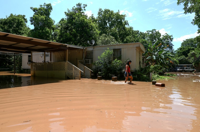 Irene Martinez, who lives near the Brazos River, leaves her flooded home, May 29, 2016, in Richmond, Texas. (Photo by Jon Shapley/Houston Chronicle/AP)