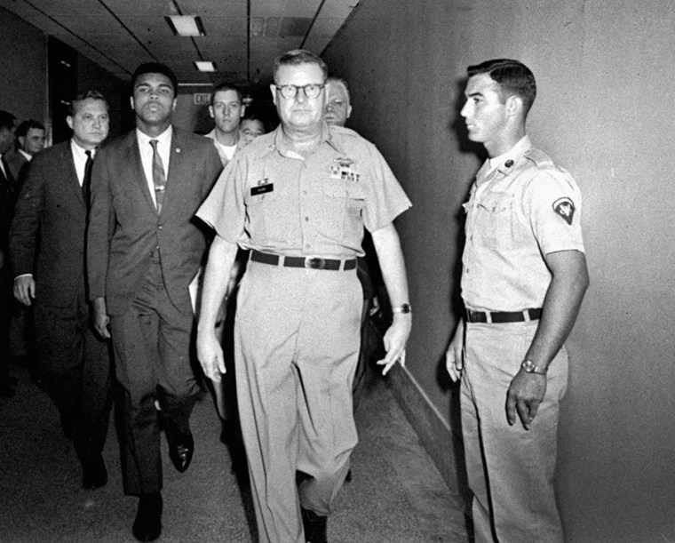 Heavyweight boxing champion Muhammad Ali is escorted from the Armed Forces Examining and Entrance Station in Houston by Lt. Col. J. Edwin McKee after Ali refused Army induction, April 28, 1967. (Photo by AP)