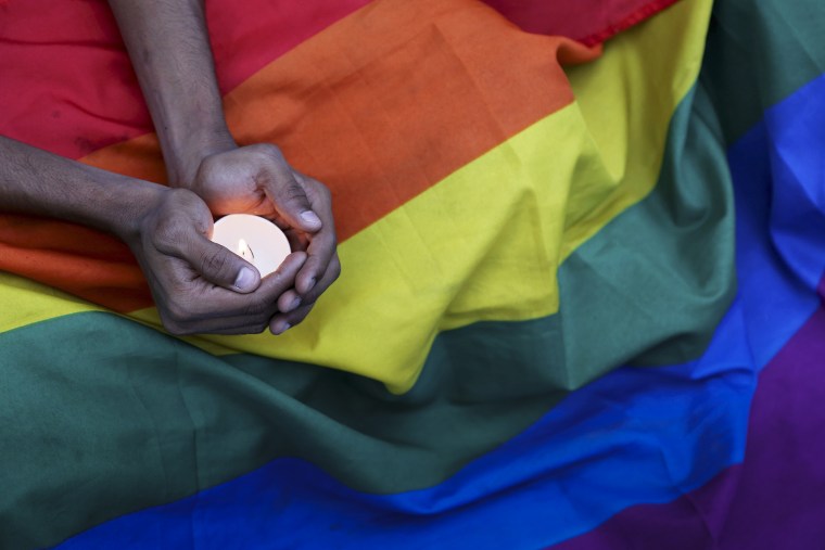 A participant holds a candle during a candlelight vigil condemning the mass shooting at the Pulse nightclub in Orlando, Fla. as they gather in Bangalore, India on June 14, 2016. (Photo by Aijaz Rahi/AP)